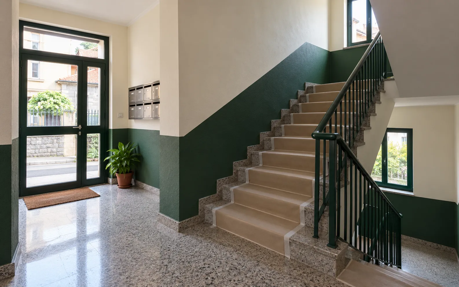 Portal comunitario con paredes renovadas y escalera; imagen ilustrativa.